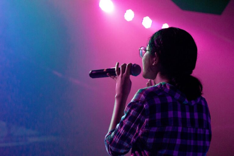 Imagen ilustrativa de una cantante con micrófono en un escenario; no muestra a Céline Dion ni el concierto informado. Foto de Forja2 Mx en Unsplash.
