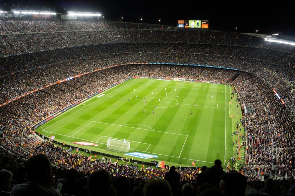 Estadio de fútbol con público. Imagen ilustrativa; no muestra el partido reportado. Krzysztof Dubiel / Unsplash.